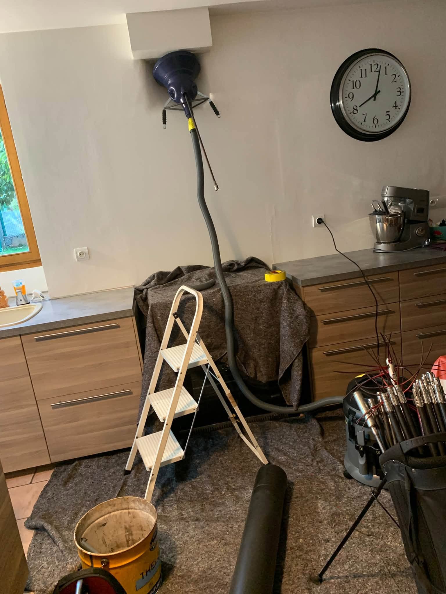 Ramonage par le bas d'un poêle à granulés à la brosse motorisée, cuisine protégée